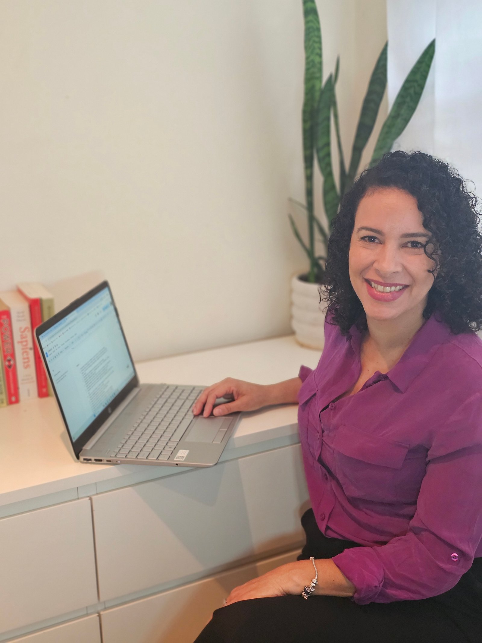 Cibele Moreira, founder of Story Social Lab, working at her desk